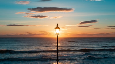 轮廓的灯柱在海滨日落
